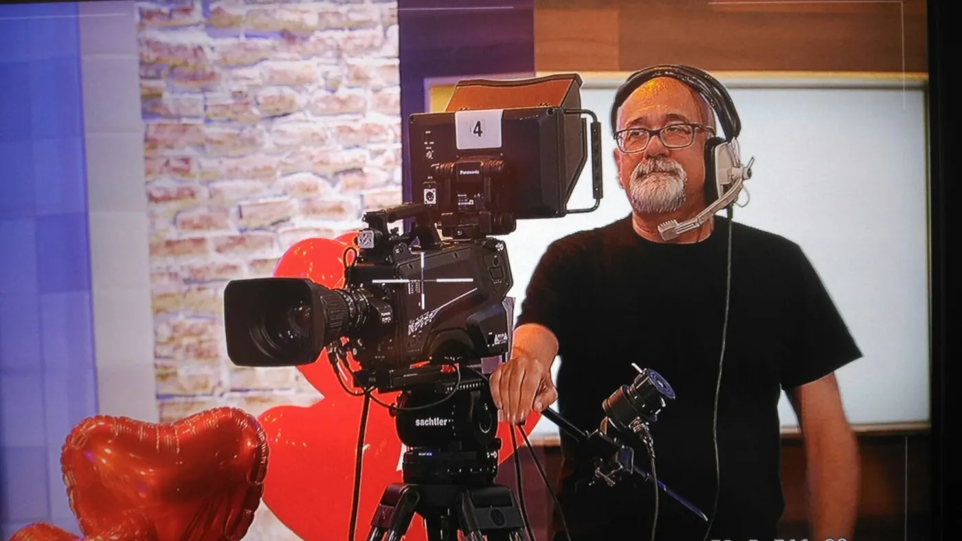 Miguel con auriculares junto a una cámara de estudio en un plató